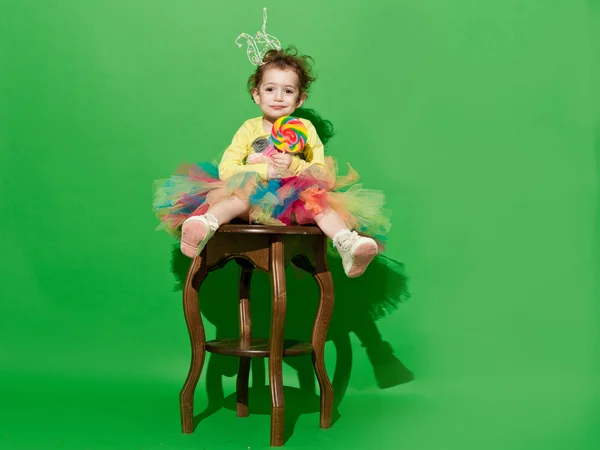 Meisje is in studio op groene achtergrond in verschillende outfit — Stockfoto