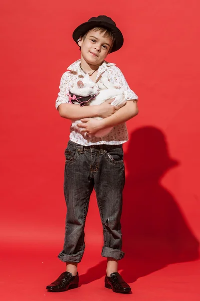 Niño con gato en el fondo rojo . — Foto de Stock