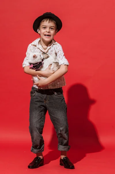 Niño con gato en el fondo rojo . — Foto de Stock