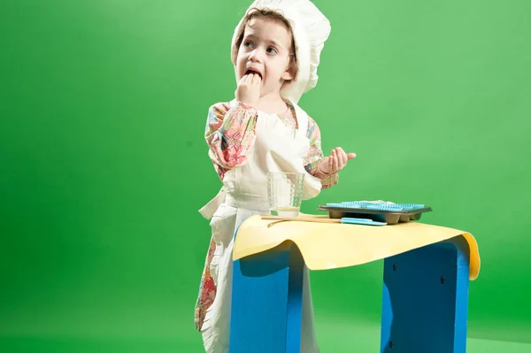 Menina pequena cozinhar no chapéu do chef e avental — Fotografia de Stock
