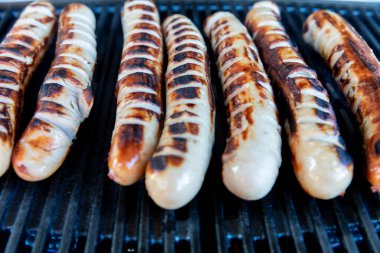Pork - beef sausages on grill in the summer garden