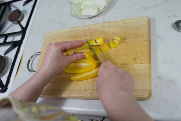 Cutting yellow peppers. — Stock Photo, Image