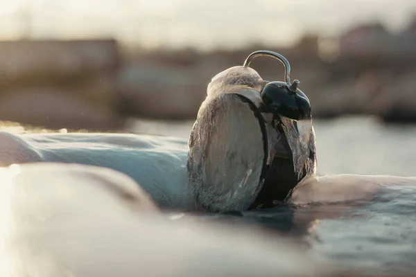 Frozen time. A clock frozen in ice. Extreme weather situation. Daylight saving time shift