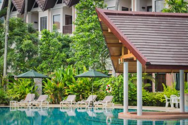 Yüzme Havuzu etrafında şemsiyelerle kanepeler