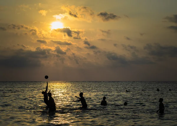 Silhouetted gruppo di ragazzo sono giocare un palla in il mare — Foto Stock