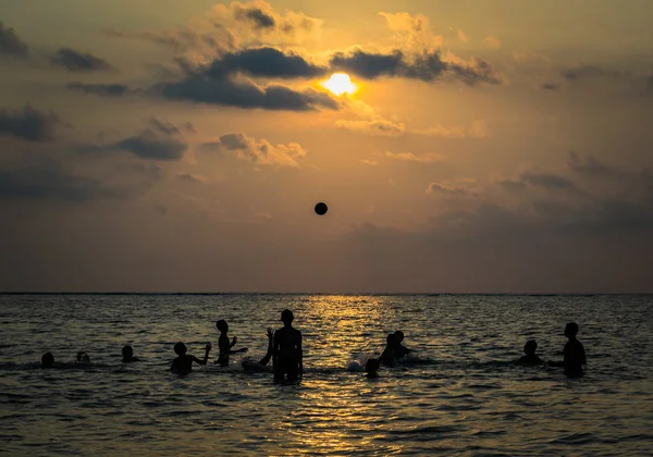 Silhouetted gruppo di ragazzo sono giocare un palla in il mare — Foto Stock