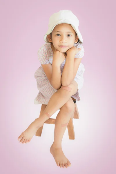 Injury cute girl sitting on wooden seat — Stock Photo, Image