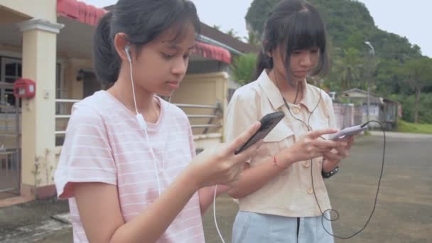 Twee Aziatische Schattige Tienermeisjes Dragen Oortelefoons Genieten Van Chatten Bericht — Stockvideo