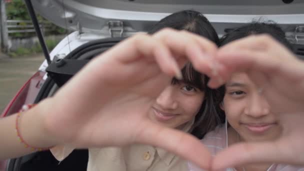 Glückliche Zwei Asiatische Teenie Schwestern Die Handbewegungen Herzform Machen Und — Stockvideo