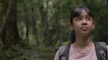 Sırt çantalı Asyalı güzel kız Phang Nga 'da tropikal yağmur ormanlarını keşfederken etrafa bakıyor. Tayland orman macerası. Ormanda yürüyüş gezisi. Genç gezginler için yaz etkinlikleri.
