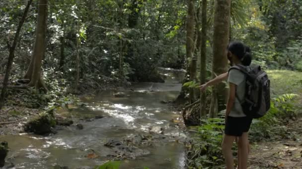 배낭을 근처에서 아시아의 소녀는 아름다운 경치를 즐긴다 정글을 지나는 계획이야 — 비디오