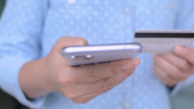 Çevrimiçi internet bankacılığı uygulaması üzerinden akıllı telefondan yazı yazan yakın iş kadını. Çevrimiçi mağazada satın alma yapmak için mobil cihaz ve kredi kartı kullanmak. 