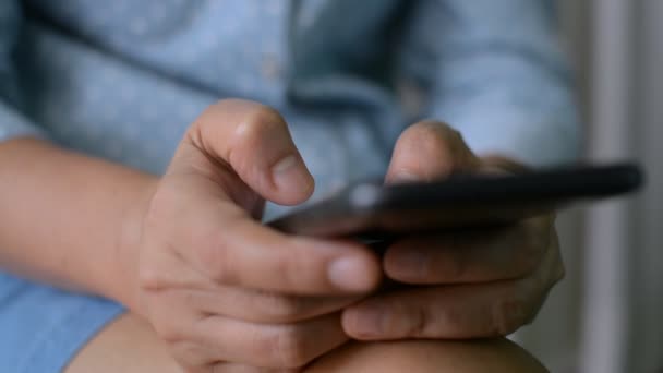 閉鎖女性は自宅に座っている間 携帯電話上のテキストメッセージを手 ワイヤレスモバイル技術と社会通信ネットワーク上でオンラインチャット 家庭分離中の現代生活 — ストック動画