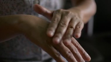 Kadın elinin bakımı. Geceleri cildine krem süren bir kadın. Ağrıyı dindirmek için tematik merhem şişkinliği ve iltihabı azaltır..