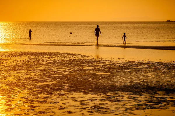 Familly na praia em pôr-do-sol laranja — Fotografia de Stock