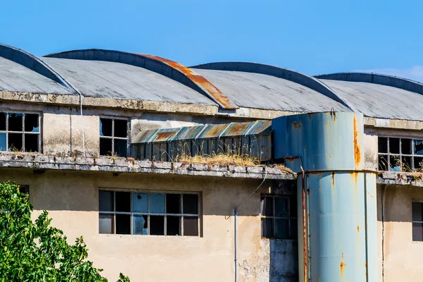 Abandoned and ruined industrial building with clear blue sky above. — Stock Photo, Image