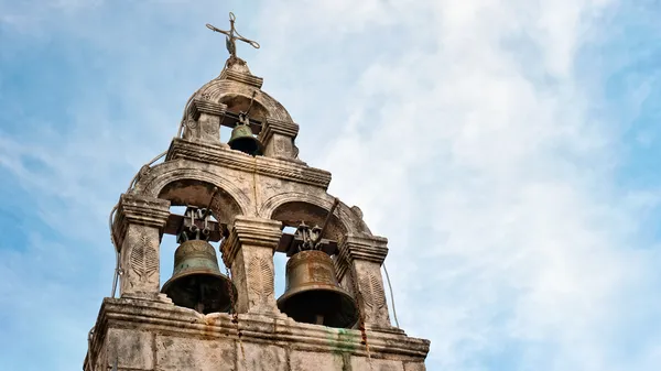 Dva staré zvony na velmi staré církve proti zamračená obloha modrá. — Stock fotografie