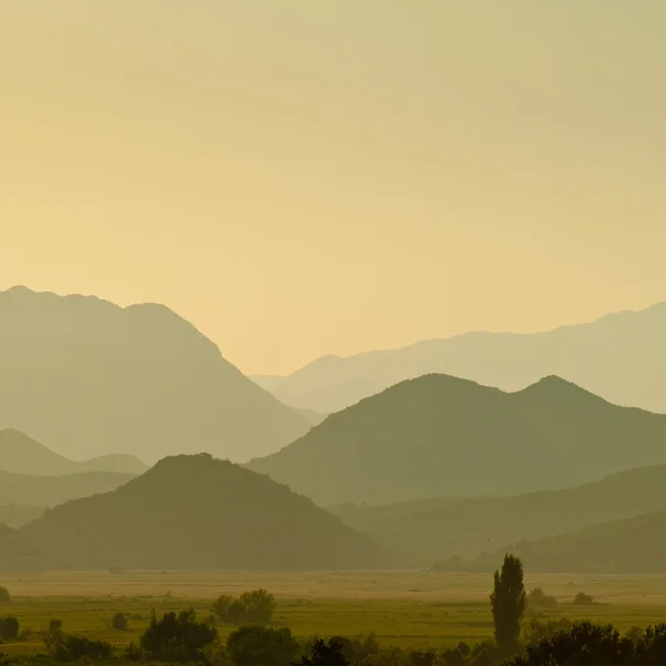 Avlägsna bergen i morgondimman över dalen — Stockfoto