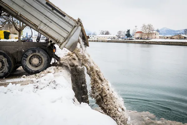 卡车卸荷雪进了河里 — 图库照片