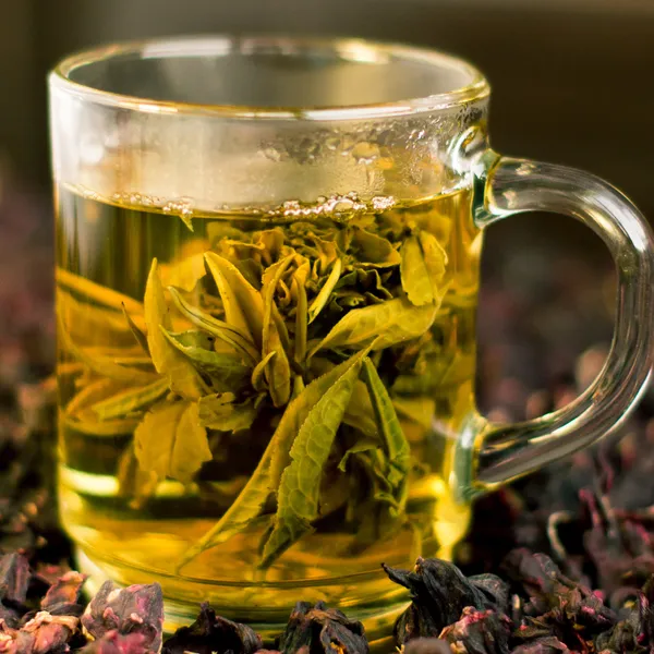Tasse grüner Tee in Form einer Blume lizenzfreie Stockbilder