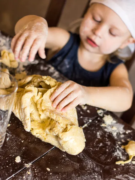 Çocukların elleri hamuru yoğurur.
