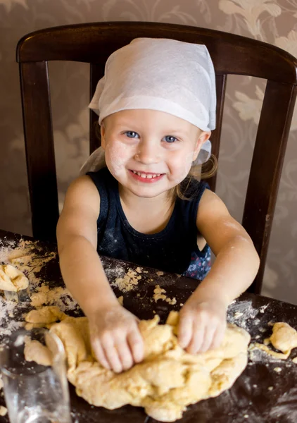 Child knead the dough in a kerchief Stock Image