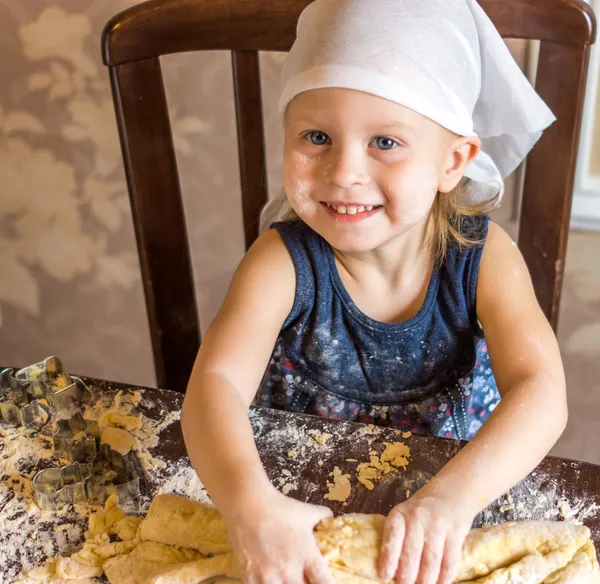 Ребенок месит тесто в платке — стоковое фото