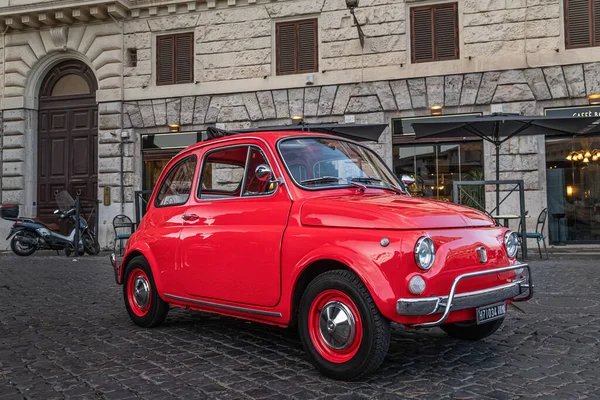 Roma, İtalya 17.07.2021: Küçük kırmızı Fiat 500 gün batımında kolezyumun önünde ve arkasında piknik sepeti ile