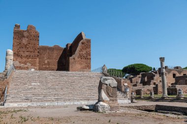 Ostia Antica arkeolojik kazılarda Capitolium kalıntıları, sütunlar ve heykel ve kabartma kalıntıları ile çevrili