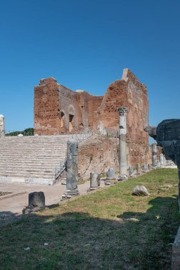 Ostia Antica arkeolojik kazılarda Capitolium kalıntıları, sütunlar ve heykel ve kabartma kalıntıları ile çevrili