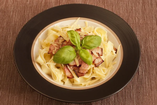 Tagliatelle pasta with ham with basil — Stock Photo, Image