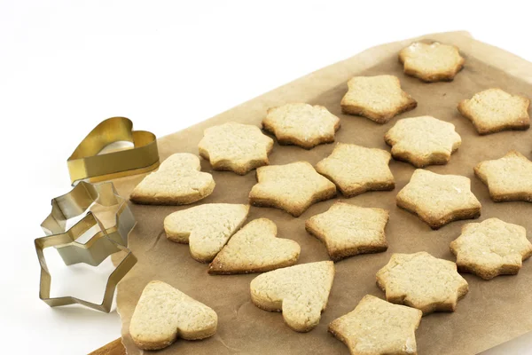 Biscuits de Noël et boîtes de cuisson sur un papier à pâtisserie — Photo