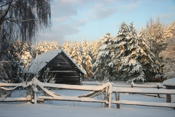 Dřevěný dům v zimním lese, západ slunce — Stock fotografie