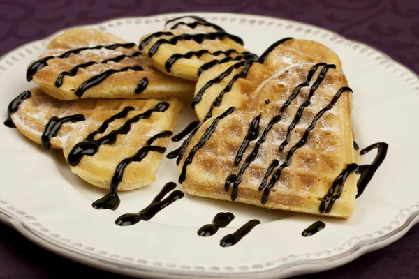 Zoete wafer harten op een schotel met chocolade saus — Stockfoto