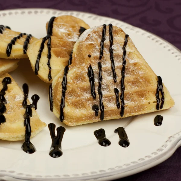 Zoete wafer harten op een schotel met chocolade saus — Stockfoto