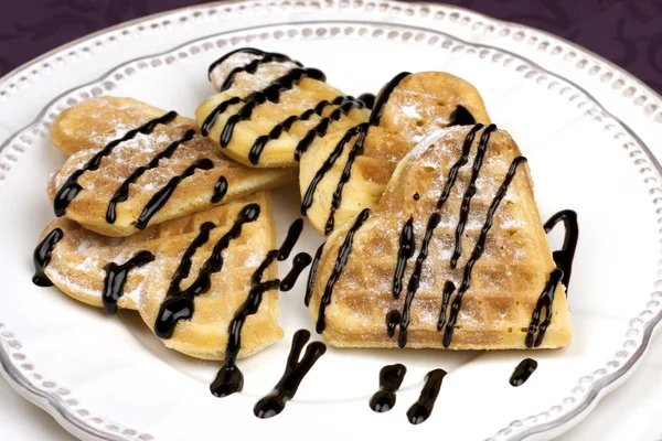 Zoete wafer harten op een schotel met chocolade saus — Stockfoto