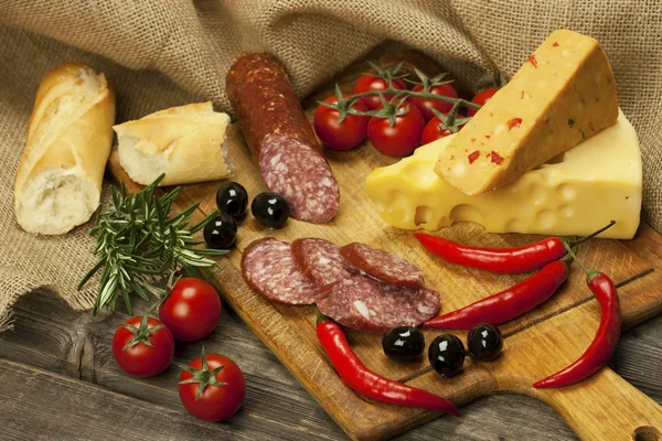 Salami and cheese platter with vegetable and herbs — Stock Photo, Image