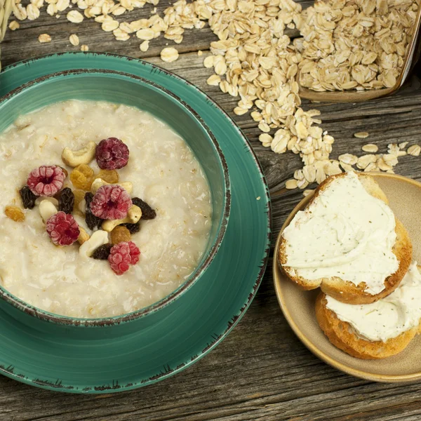 Haferbrei mit Himbeeren und Rosinen in einer Schüssel — Stockfoto