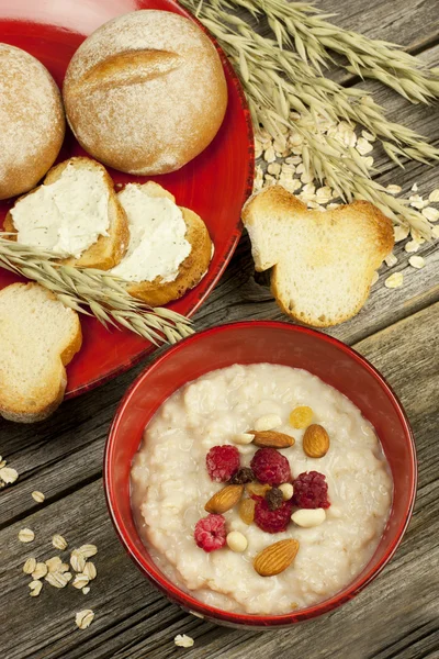 Oatmeal porridge with raspberry and raisins in a bowl — Stock Photo, Image