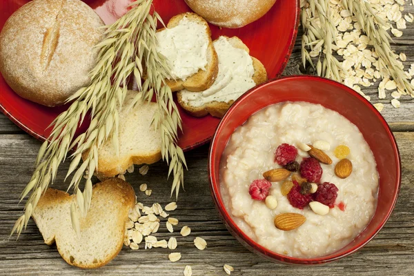 Oatmeal porridge with raspberry and raisins in a bowl — Stock Photo, Image