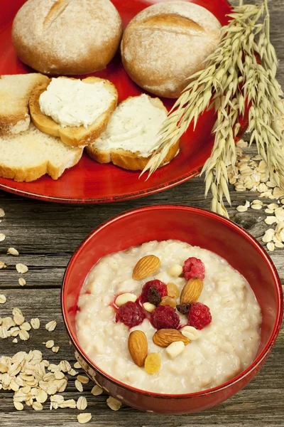 Porridge di farina d'avena con lampone e uva passa in una ciotola — Foto Stock