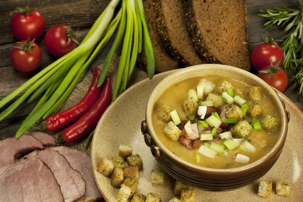 Pea soup with carrot and bacon in pot — Stock Photo, Image