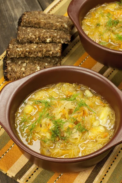 Zuurkool soep in keramische kom op houten tafel — Stockfoto