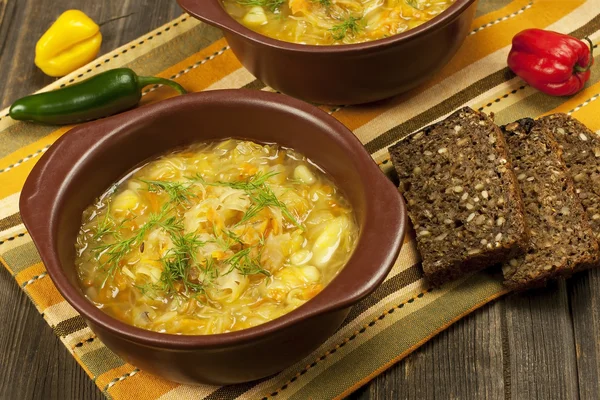 ahşap masa üzerinde seramik kase lahana çorbası