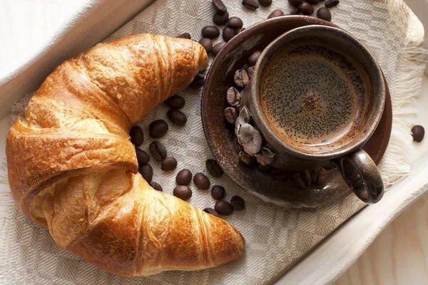 Croissant en koffie op houten tafel — Stockfoto