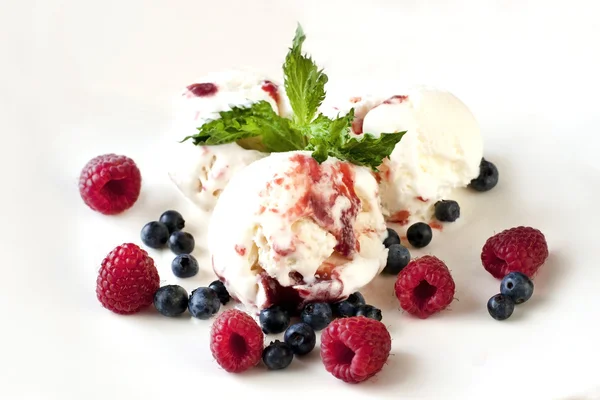 Balls of ice-cream garnished with berries on white plate — Stock Photo, Image