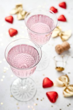 Kutlama arkaplanı, arka planda iki kristal şampanya bardağı ve parti aksesuarları. Romantik konsept