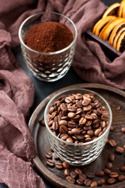 Koyu arkaplanda kahve ve kahve çekirdekleri olan kompozisyon, sığ alan derinliğinde seçici odak