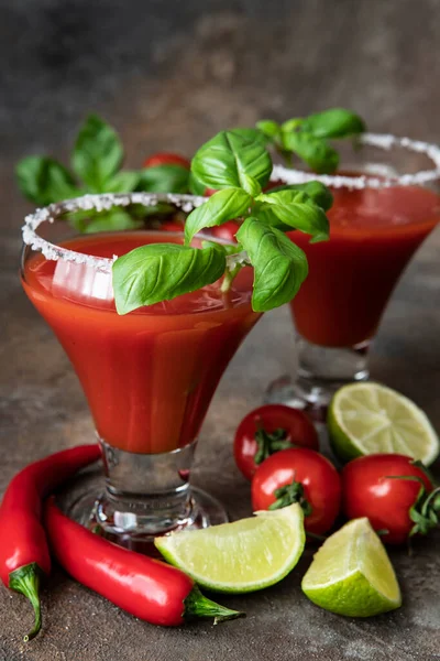 Fesleğen yaprakları ve kiraz domatesleriyle servis edilen Bloody Mary kokteyli.