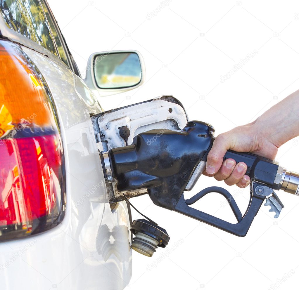 Hand holding a nozzle while fueling white car. Focus on the nozz